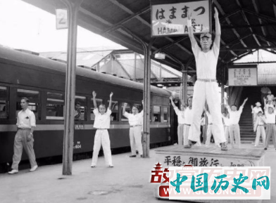 月台上有人示范健身操，让乘搭长途车的乘客学会做此健身操以避免身体过度疲劳